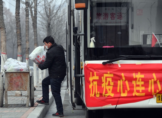 1月10日，在河南省禹州市寨子社区，工作人员将蔬菜包卸车。新华社记者 李嘉南 摄