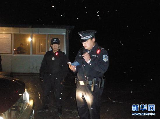 韩顺军(右)在冒雪工作(2011年1月1日摄)。新华社发(绵竹市公安局供图)