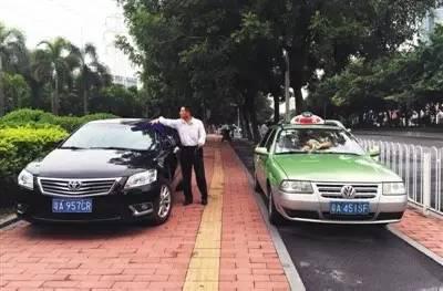 今年8月10日,广州市街头,一位网约车司机和一位出租车司机一边擦车一边聊天。图/视觉中国