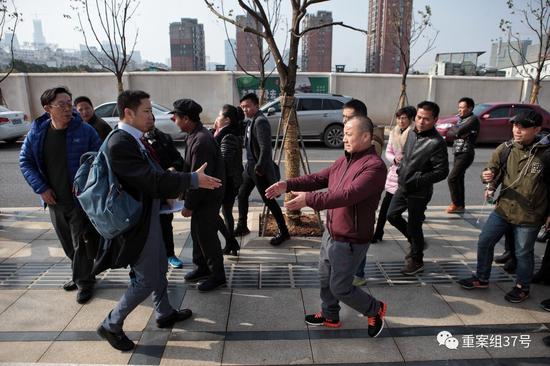 12月22日,被判无罪的黄志强(穿红黑运动鞋者)走出法院和律师握手。新京报记者 王嘉宁 摄