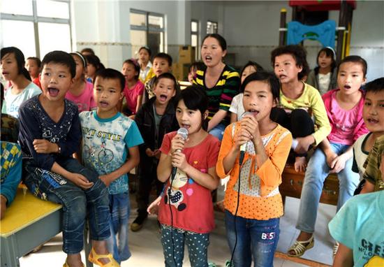2016年5月26日,在广西大化瑶族自治县板升乡弄勇小学,孩子们在电教室里唱歌。 新华社记者 黄孝邦 摄