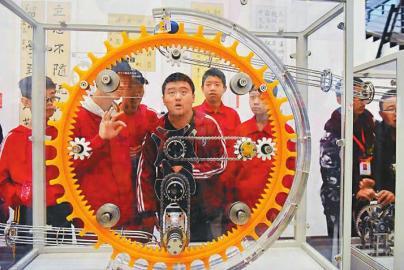 10月20日，在绵竹市文化馆展厅，学生在中国流动科技馆巡展现场观看展品“机械韵律”。王平摄（视觉四川）