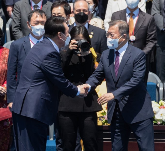  ·5月10日，尹锡悦（前排左）在就职典礼结束后，与文在寅握手分别。