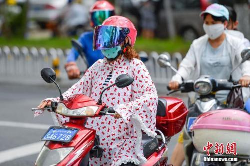 资料图:海口市民在高温下“全副武装”出行。中新社记者 骆云飞 摄