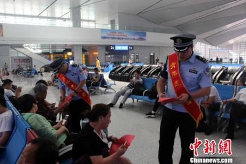 资料图: 青岛铁路公安处民警向旅客发放安全宣传资料。 梁西征 摄