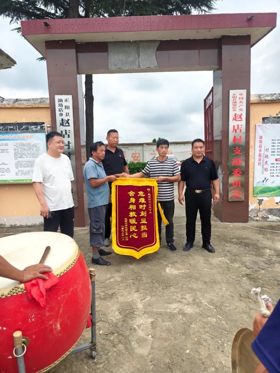 获救村民家人向王富业赠送锦旗(右二)
