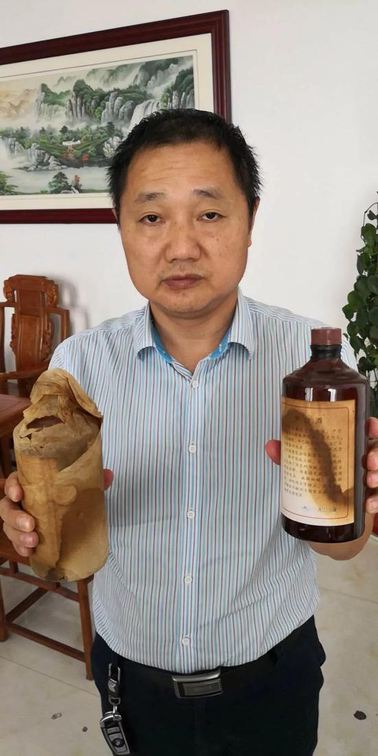 ▲律师阳曙文拿着他网购的“贵州茅台酒”