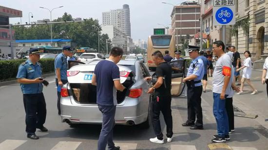 2018年8月1日上午,济南火车站,一辆注册某网约车平台的轿车被执法人员拦下接受检查。图/大众网潍坊
