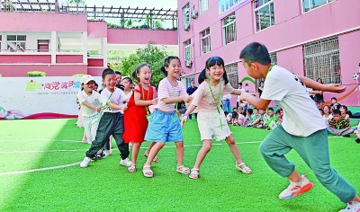 浙江仙居县第一小学内，一年级新生们正在玩老鹰捉小鸡游戏。王华斌摄/光明图片