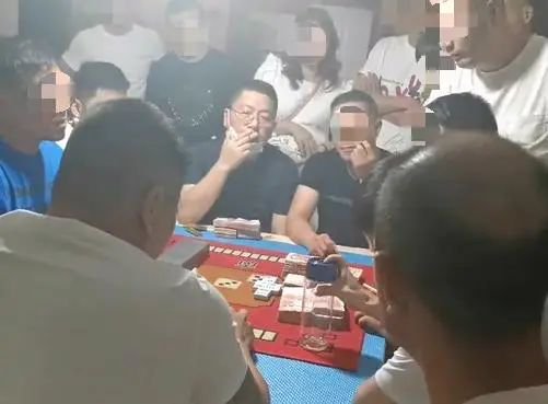 ▲湯恕與人聚眾賭博的影片截圖,坐在中間戴著眼鏡的抽菸男子為湯恕。影片截圖
