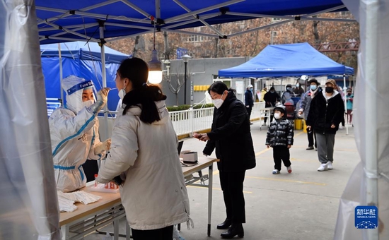 12月27日，在西安市碑林区张家村街道太白社区，居民在接受核酸检测。新华社记者 陶明 摄