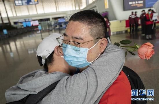 3月19日，在武汉天河机场，河南医疗队队员郭燕姿紧紧抱住丈夫王国晓。