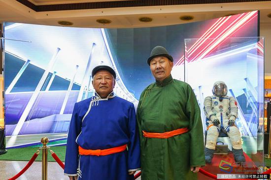 12月28日上午,“胡杨魂 航天情 中国梦——内蒙古人民助力中国航天60周年图片展”在北京民族文化宫开展。图为内蒙古自治区阿拉善盟额济?#21892;?#30340;牧民根登(左)和同伴。千龙网记者 耿子叶摄