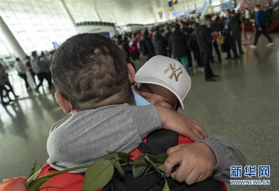 3月19日，在武漢天河機場，河南醫(yī)療隊隊員郭燕姿緊緊抱住丈夫王國曉。