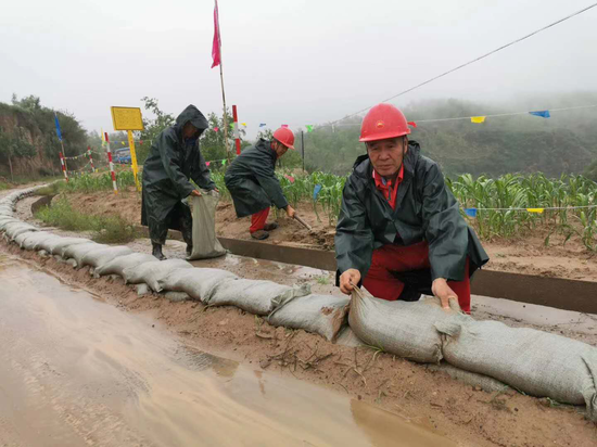 图为北京管道陕西处员工在防汛现场设置临时挡水墙
