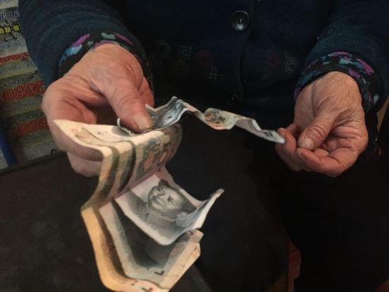 奶奶手里拿着的50元是一家人全部的钱。上游新闻记者 张曼双 摄