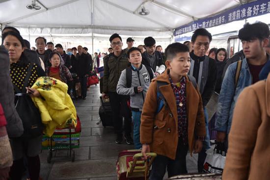 石欣随着返乡的客流,排队等待进站。