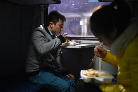 列车上的晚餐是一份15元的盒饭,有肉丝和煎蛋,但他最想念的味道还是家里的腊肉。