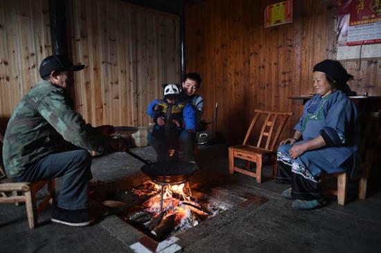 石欣把儿子抱回屋里,在柴火旁取暖。