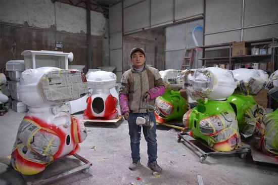 1月16日,石欣在广州工作的厂子里,身旁是他要喷漆的动漫玩具。