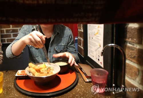 资料图片：2016年3月20日，在首尔新村的一家餐厅，一名顾客用餐。（韩联社）