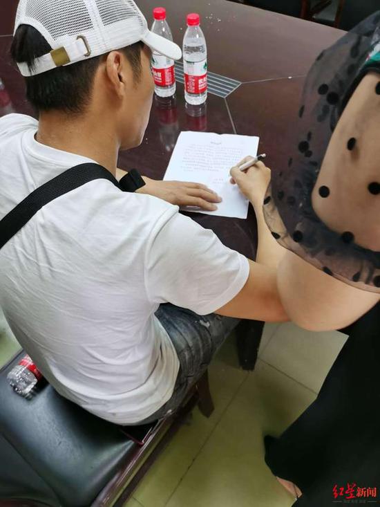 ↑獲救女子的父親程先生在寫情況說明 攝影 彭亮