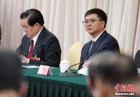 3月8日,十三届全国人大一次会议河北省代表团在北京举行全体会议。图为全国人大代表、河北省副省长、雄安新区管委会主任陈刚(右)出席会议。 中新社记者 毛建军 摄