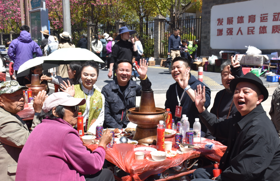 新丽江人在长街宴中品尝丽江美食&nbsp;。（丽江融媒记者 杨四娟 摄）