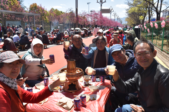 丽江市民和来自北京的游客同桌品尝丽江美食。（丽江融媒记者 杨四娟 摄）