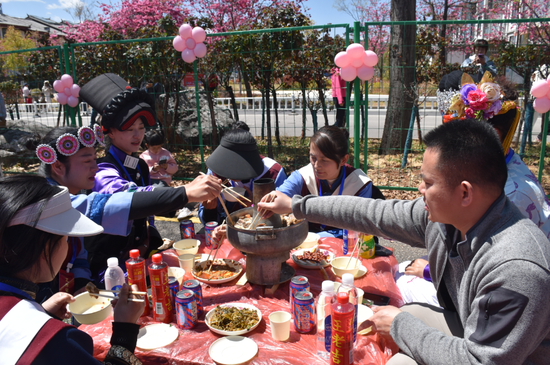 身穿不同民族服饰的市民一起品尝丽江美食。（丽江融媒记者 杨四娟 摄）