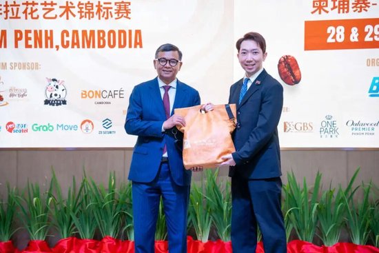 普洱南亚科技创业园执行董事向柬埔寨副首相兼教育、青年和体育部大臣韩春那洛赠送“普洱咖啡师”品牌文创