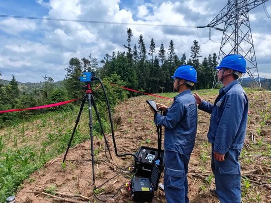 六盘水供电局输电管理二所采用不停电作业方式，运用激光清障仪对树障隐患进行清理，为高考稳定供电保驾护航。任华夏 邵静 摄