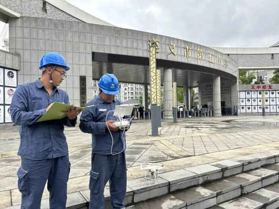 遵义市郊供电局高桥供电所工作人员启动无人机对考点线路开展巡视排查隐患。郑婷 摄
