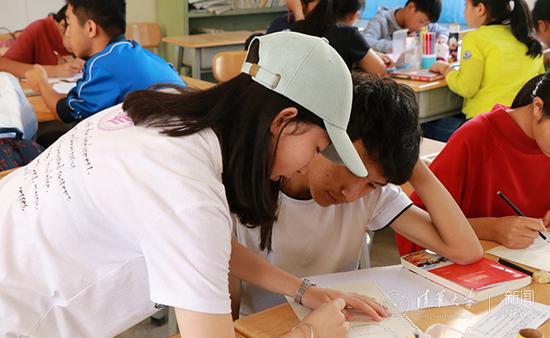 队员指导学生制作手抄报并交流阅读感悟。