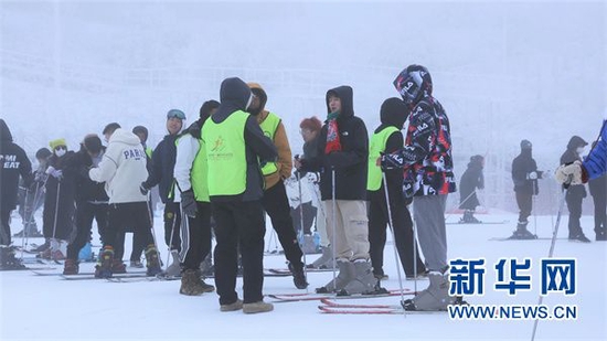 教练向参与体验的学生们讲解滑雪技巧。新华网 蔡连素 摄