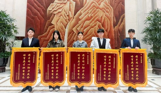 郭必林（右一）作为学校代表，接受两会驻地酒店赠予云南工商学院的锦旗