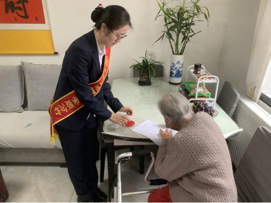 (若飞支行工作人员耐心指导老人家签名)