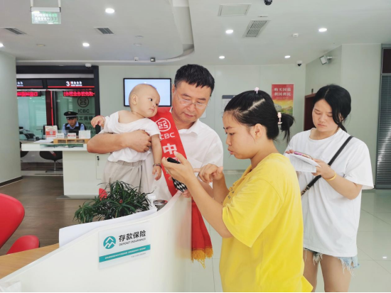 (该行工作人员正在引导客户使用手机银行)