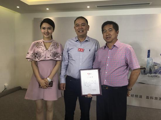 曲靖市副市长张向明(中)与曲靖市旅发委主任谭增权(右)领取荣誉证书