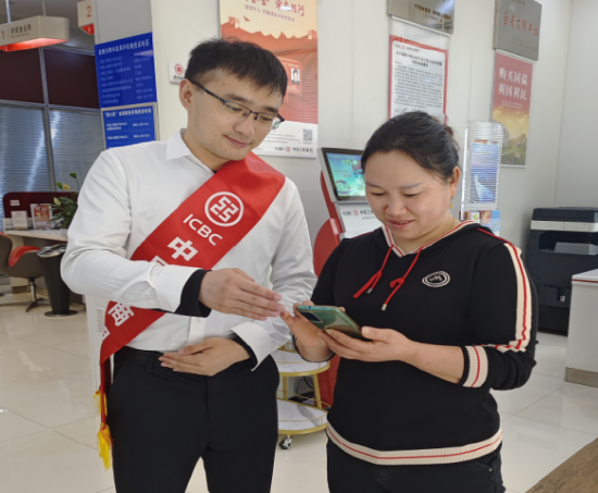 (工商银行岑巩支行客服经理正在指引客户通过手机银行申请“融e借”)