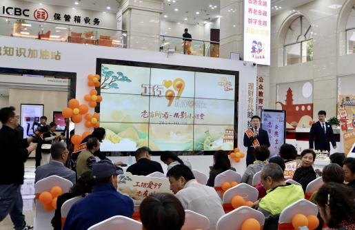 图为该行工作人员面向参与活动的银发客群介绍活动流程