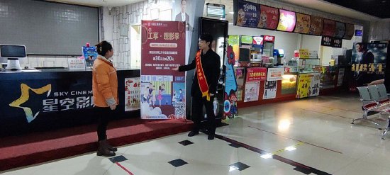 工作人员在电影院布放工享·观影季活动海报