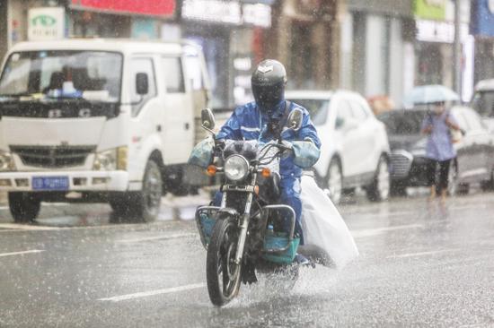 一名送餐员冒雨送餐。图/高强