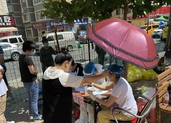 ▲热心居民,为沙河口区幸福社区工作者打伞遮阳。