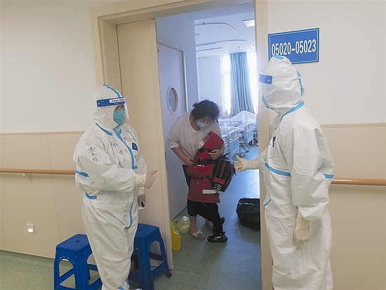我市方舱医院专门设置了家庭病房、亲子病房。图为医护人员安排母子团聚。受访者供图