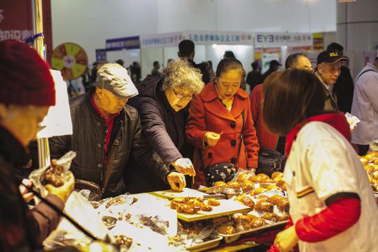消费者在食品展柜品尝。