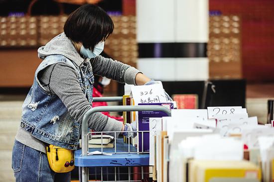 图书馆工作人员对市民在网上预约要借的图书归类编号。