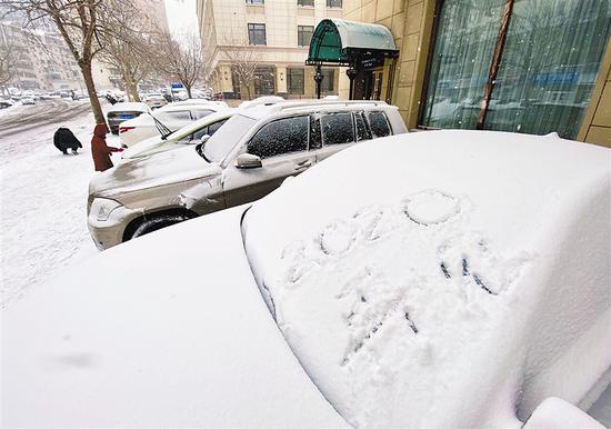 大连迎来2020年最后一场雪,市区内银装素裹冬意盎然。一个路人在被白雪覆盖的车身上写下“2020,再见”的字样。大连新闻传媒集团记者钟启钢 摄