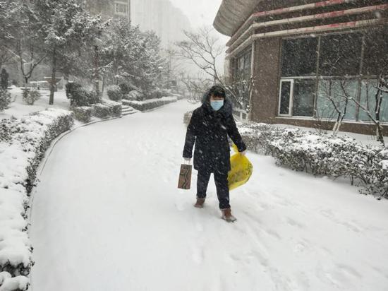 ▲王超冒雪为居家隔离居民送生活物资