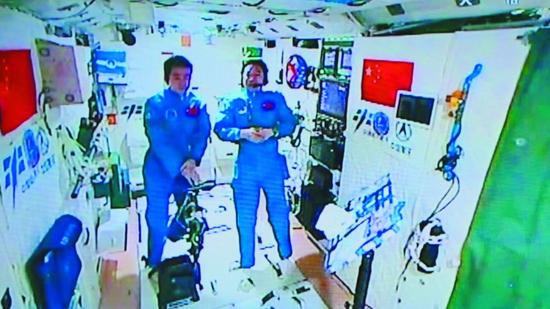 11月15日,景海鹏(右)和陈冬在天宫二号首次接受“天地采访”。新华社发